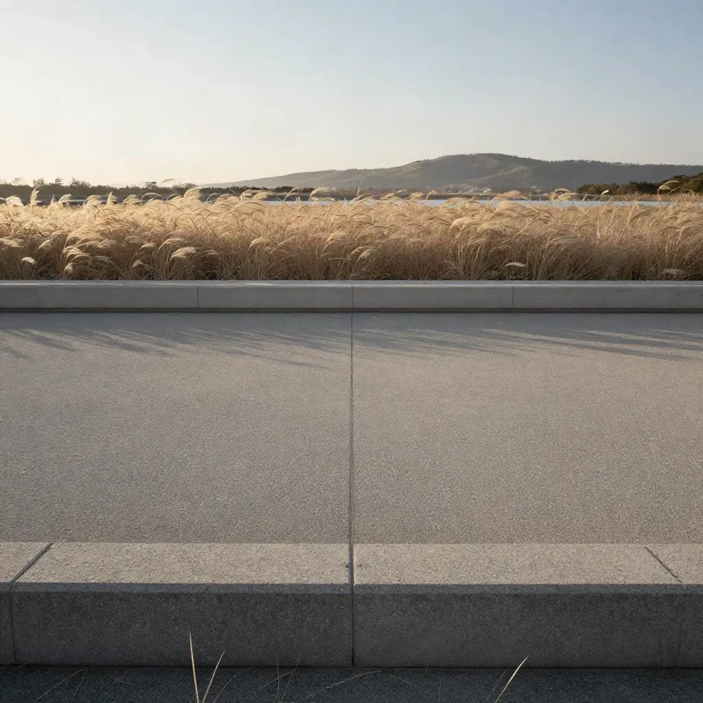 Inzai meadow grass, pale reservoir line, and a hazy low hill at golden hour.